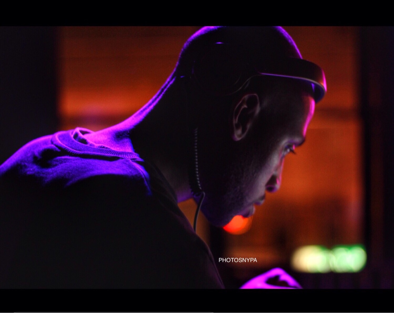 DJ DC performing under purple stage lights